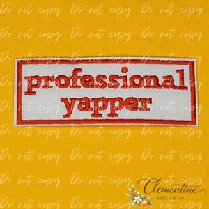 May include: A rectangular embroidered patch with a white background and a red border. The text professional yapper is stitched in red, lowercase, serif font across the center of the patch. The design is clean, bold, and features clear lettering.