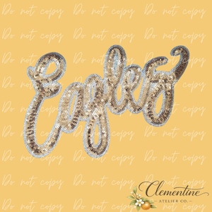 May include: A script-style patch featuring the word Eagles spelled out in shimmering gold sequins with a silver sequin border. The lettering is connected in a cursive font, creating a decorative applique design with a reflective, textured surface.