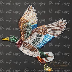 May include: A sequin patch shaped like a flying mallard duck. The duck features a green head, a white neck ring, a dark red chest, and wings with brown, white, and blue sequins. The beak is yellow, and the body is covered in iridescent sequins.