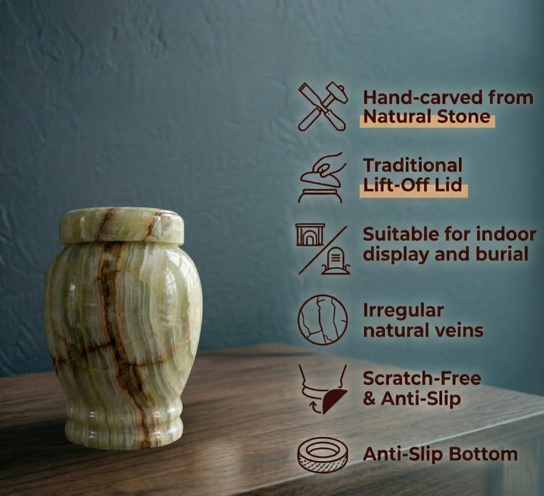 May include: A cylindrical urn crafted from light green natural stone with brown veining and a matching lift-off lid. Text on the right lists features: Hand-carved from Natural Stone, Traditional Lift-Off Lid, Suitable for indoor display and burial, Irregular natural veins, Scratch-Free & Anti-Slip, and Anti-Slip Bottom.