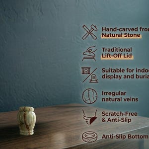 May include: A small, cylindrical stone urn with a light green and brown veined pattern and a matching lift-off lid. Text features include: Hand-carved from Natural Stone, Traditional Lift-Off Lid, Suitable for indoor display and burial, Irregular natural veins, Scratch-Free & Anti-Slip, and Anti-Slip Bottom.