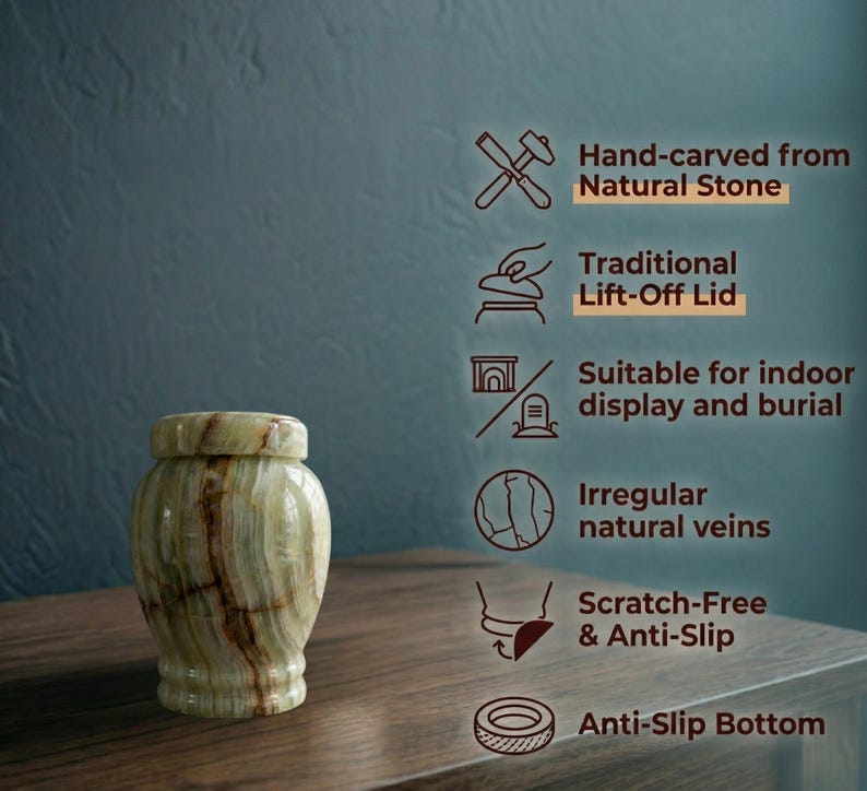 May include: A light green and brown natural stone urn with a lift-off lid. Text features include: Hand-carved from Natural Stone, Traditional Lift-Off Lid, Suitable for indoor display and burial, Irregular natural veins, Scratch-Free & Anti-Slip, Anti-Slip Bottom.