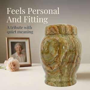 May include: A polished green and brown banded onyx urn with a matching lid. The urn features natural swirling patterns and a smooth, glossy finish. The text "Feels Personal And Fitting" and "A tribute with quiet meaning" appears in the background.