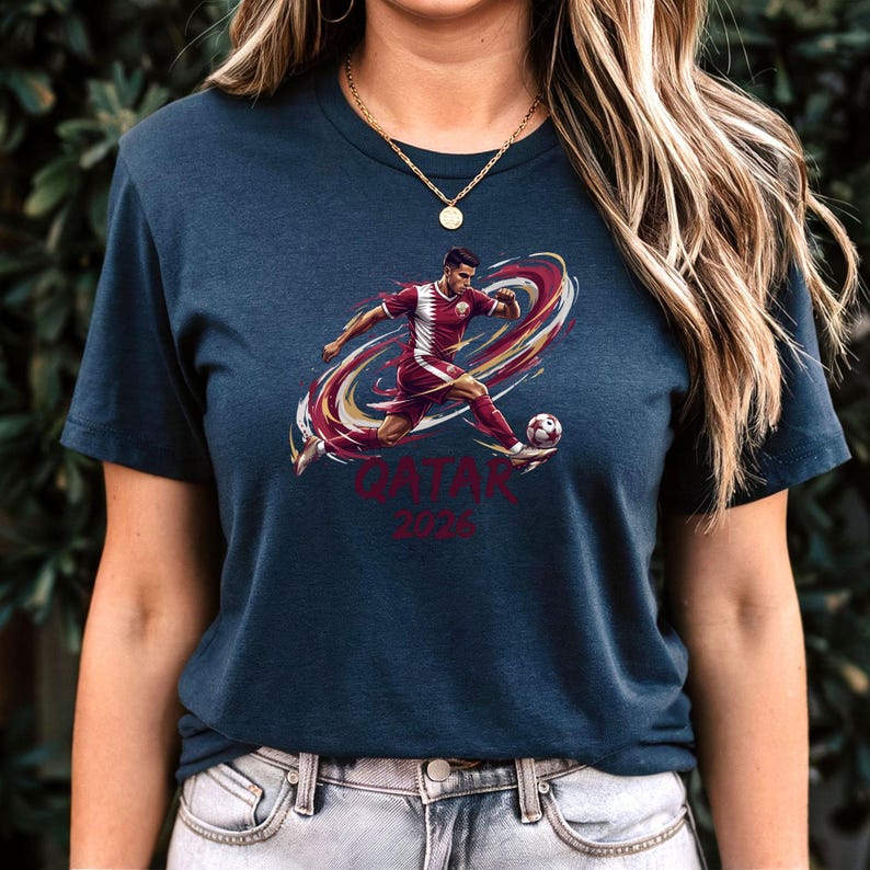 A woman wearing a dark blue t-shirt with a graphic of a soccer player and the text "QATAR 2016" printed on it.