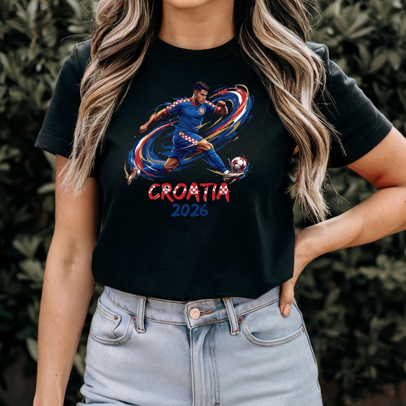 A woman wearing a black t-shirt with a graphic of a soccer player and the text "Crotia" and "2026" printed on it.