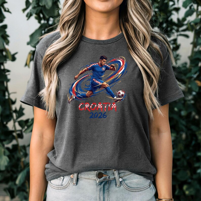A woman wearing a grey t-shirt with a graphic of a soccer player and the text "Croatia 2026" printed on it.