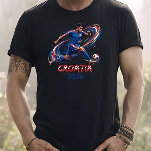 A person wearing a black t-shirt with a graphic of a soccer player kicking a ball, along with the text "Croatia 2026".