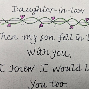 May include: Handwritten card with a decorative border of hearts and vines. The card reads "Daughter-in-law When my son fell in love With you, I knew I would love You too."