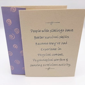 May include: A card with a light purple background and pink swirls. The card has a handwritten message that reads: "People with siblings have better survival skills because they've had experience in physical combat, psychological warfare & sensing suspicious activity."