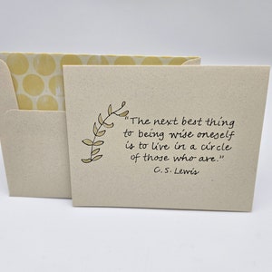 May include: A beige card with a yellow envelope. The card features a handwritten quote by C.S. Lewis: "The next best thing to being wise oneself is to live in a circle of those who are."