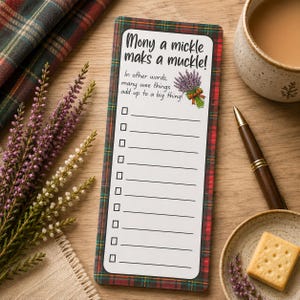 May include: A rectangular notepad with a red, green, and yellow plaid border. The white centre features the text Mony a mickle maks a muckle! In other words, many wee things add up to a big thing! with a lavender illustration and ten blank lines.