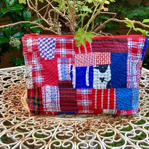 以下が含まれることがあります： 赤と青のパッチワークのジッパー付きポーチで、キルティングのデザインが施されています。ポーチはさまざまな生地で作られており、格子柄、ギンガムチェック、ストライプなど、さまざまなパターンがあります。