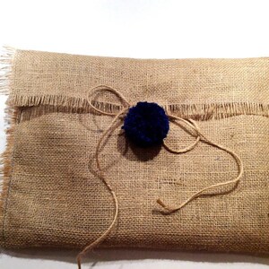 May include: A brown burlap gift bag with a blue pom-pom tied with twine.