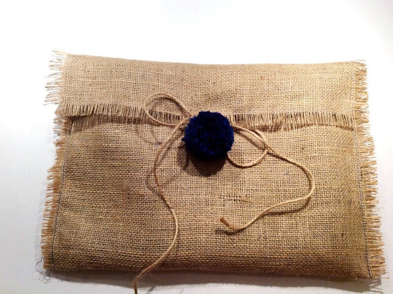 May include: A brown burlap gift bag with a blue pom-pom tied with twine.