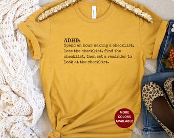 Può includere: Una maglietta gialla con il testo "ADHD: Spend an hour making a checklist, lose the checklist, find the checklist, then set a reminder to look at the checklist." stampato in nero.