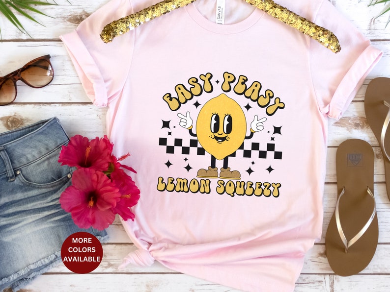 K&ouml;nnte beinhalten: Pinkes T-Shirt mit einem gelben Zitronen-Motiv und dem Text "Easy Peasy Lemon Squeezy".