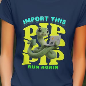 May include: Navy blue t-shirt featuring a green snake with a laptop and a mug. The shirt has the words "IMPORT THIS PIP PIP PIP RUN AGAIN" in yellow and turquoise. The design is a playful take on programming.
