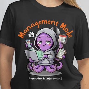 May include: Black t-shirt featuring a cartoon octopus in a gray hoodie, holding a laptop, phone, calendar, and clipboard. The text "Management Mode" arches above the octopus, with "Everything is under control" below.