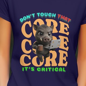 Könnte beinhalten: Marineblaues T-Shirt mit einem Cartoon-Eber, der einen Laptop und eine Tasse hält. Der Text "DON'T TOUCH THAT CORE, IT'S CRITICAL" ist in verschiedenen Farben dargestellt. Das Design ist mittig auf der Vorderseite.