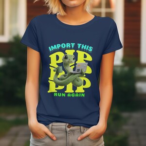 May include: Navy blue t-shirt with a cartoon snake using a laptop and holding a coffee cup. The text "IMPORT THIS PIP PIP PIP RUN AGAIN" is in yellow and teal. A quirky graphic tee.