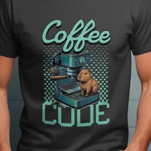 May include: Dark gray t-shirt featuring a teal coffee machine illustration with a capybara and the words "Coffee CODE". The design has a pixelated background and a vintage aesthetic.