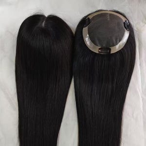 May include: Two black hair toppers with long, straight hair. One has a small, circular base, while the other has a simple, rectangular base. The hair appears to be a natural black colour and is styled straight.