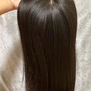 May include: A white ceramic mug with a black handle and the text "But First, Coffee" in a bold, black font. The mug is set against a blurred background, suggesting a cozy setting.