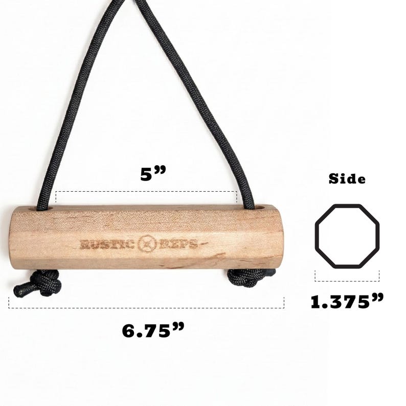 May include: A wooden pull-up bar with a black rope for hanging. The bar is 6.75 inches long and 1.375 inches wide. The text "RUSTIC REPS" is printed on the bar.