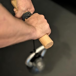 Op de afbeelding: Een witte keramische mok met een zwarte handgreep en de tekst "But First, Coffee" in een handschriftstijl. De mok staat op een wit oppervlak. De mok is ongeveer 10 cm hoog.