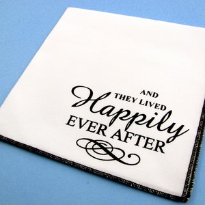 May include: White fabric napkin with black text that reads "And they lived happily ever after".