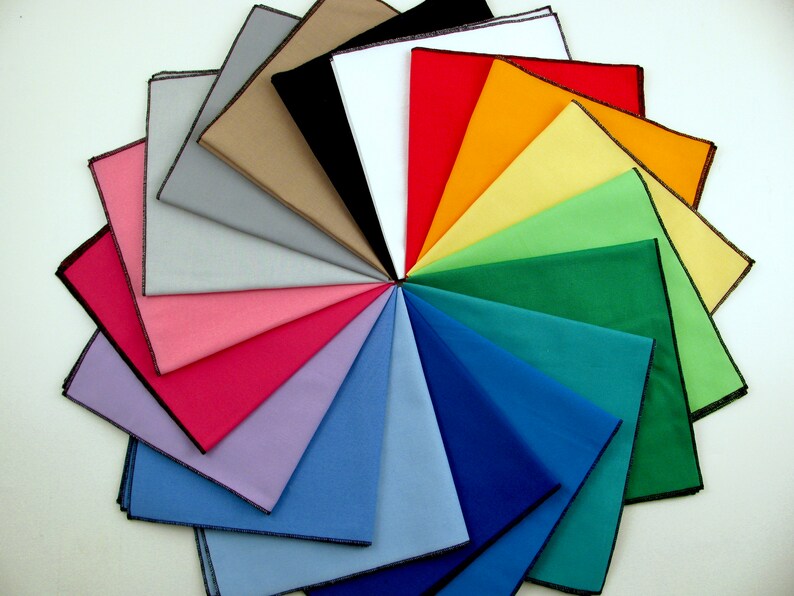 May include: A collection of 18 fabric squares in various colors, arranged in a circular pattern. The squares are all the same size and have a black border.