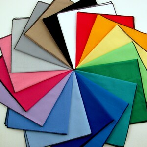 May include: A collection of 18 fabric squares in various colors, arranged in a circular pattern. The squares are all the same size and have a black border.