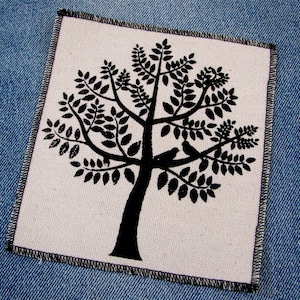 May include: A black and white silhouette of a tree with birds on the branches. The tree is on a white background with a black stitched border.