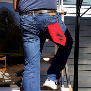 May include: A person wearing blue jeans with a red bandana in their back pocket. The bandana has a black heart with the word "Love" inside.
