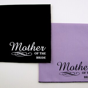 May include: Two black and lavender fabric squares with white text that reads "Mother of the Bride".