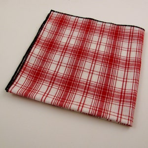 May include: Red and white plaid pocket square with a black border.