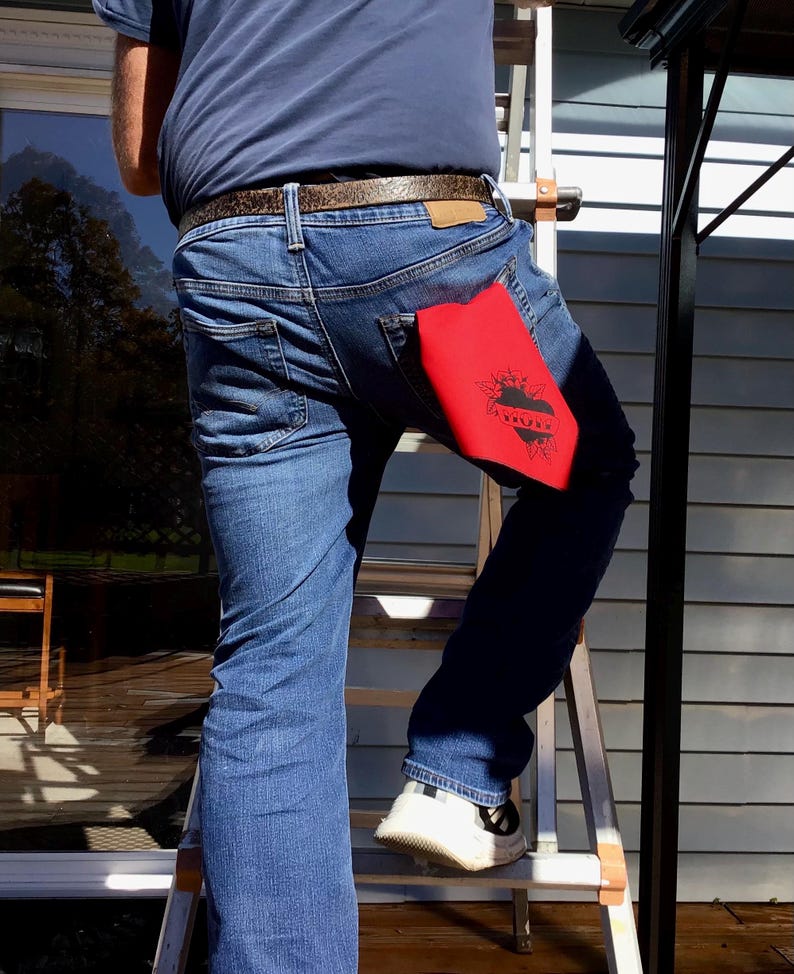 May include: A person wearing blue jeans with a red bandana in their back pocket. The bandana has a black heart with the word "Love" inside.