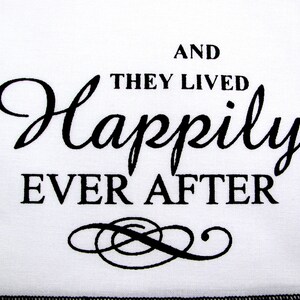 May include: White fabric with black text that reads "And they lived happily ever after" with a decorative flourish below the text.