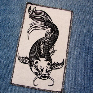 May include: Black and white embroidered patch of a koi fish with a detailed design. The fish is swimming upwards with its tail fanned out.