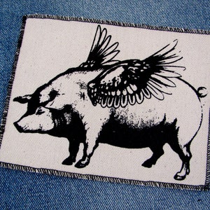 May include: Black and white iron-on patch of a pig with wings. The pig is facing left and has a detailed wing design.