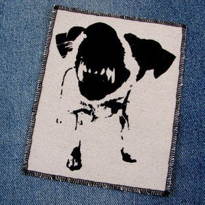 May include: Black and white iron-on patch featuring a silhouette of a snarling dog with sharp teeth.