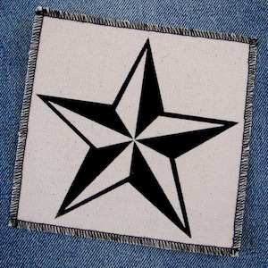 May include: A black and white star patch with a white background and a black star with five points. The star is sewn onto a piece of blue denim.