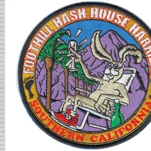 Könnte beinhalten: Runder, gestickter Aufnäher mit dem Text "FOOTHILL HASH HOUSE HARRIERS SOUTHERN CALIFORNIA". Der Aufnäher zeigt ein Cartoon-Kaninchen, das sich entspannt und ein Weinglas hält, mit Palmen und Bergen im Hintergrund.