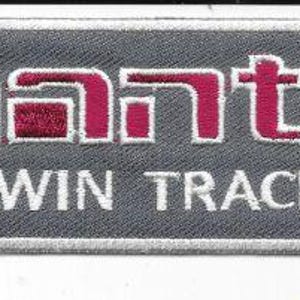 May include: A rectangular patch with the word "MANTA" in red block letters above the words "TWIN TRACK" in white. The patch has a gray background and a white border.