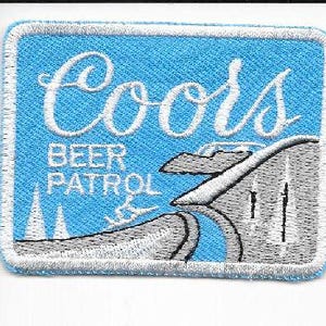 May include: Embroidered patch with a light blue background and white border. The patch features the word "Coors" in white script above the words "BEER PATROL" in white block letters. A stylized image of a roller coaster is also present.