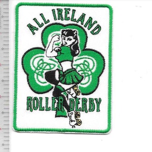 May include: Embroidered patch with a white background and a green border. The patch features a woman in a green outfit on roller skates, with the words "ALL IRELAND ROLLER DERBY" in green. A green shamrock shape is behind the woman.