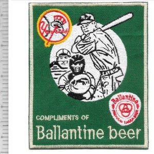 May include: A rectangular green embroidered patch featuring a baseball scene with a batter and catcher. It includes a Yankees logo, a Ballantine beer logo, and the text "COMPLIMENTS OF Ballantine beer". A ruler shows the patch is 4.5 inches tall.