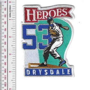 May include: Embroidered patch featuring a baseball pitcher in action. The patch includes the word "HEROES" in red, the number "53" in blue, and the name "DRYSDALE" at the bottom. The background is teal and white.