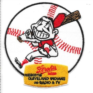 May include: Embroidered patch featuring a cartoon baseball player with a bat, set against a baseball. The patch includes the text "Lerolis Beer Presents the Cleveland Indians on Radio & TV". The design is in red, white, black, and brown.