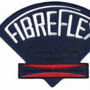 Könnte beinhalten: Ein marineblauer Aufnäher mit dem weißen Schriftzug "FIBREFLEX" in einem Bogen. Darunter eine Signatur und das Wort "MODEL". Unten befindet sich ein rotes und schwarzes Rechteck.